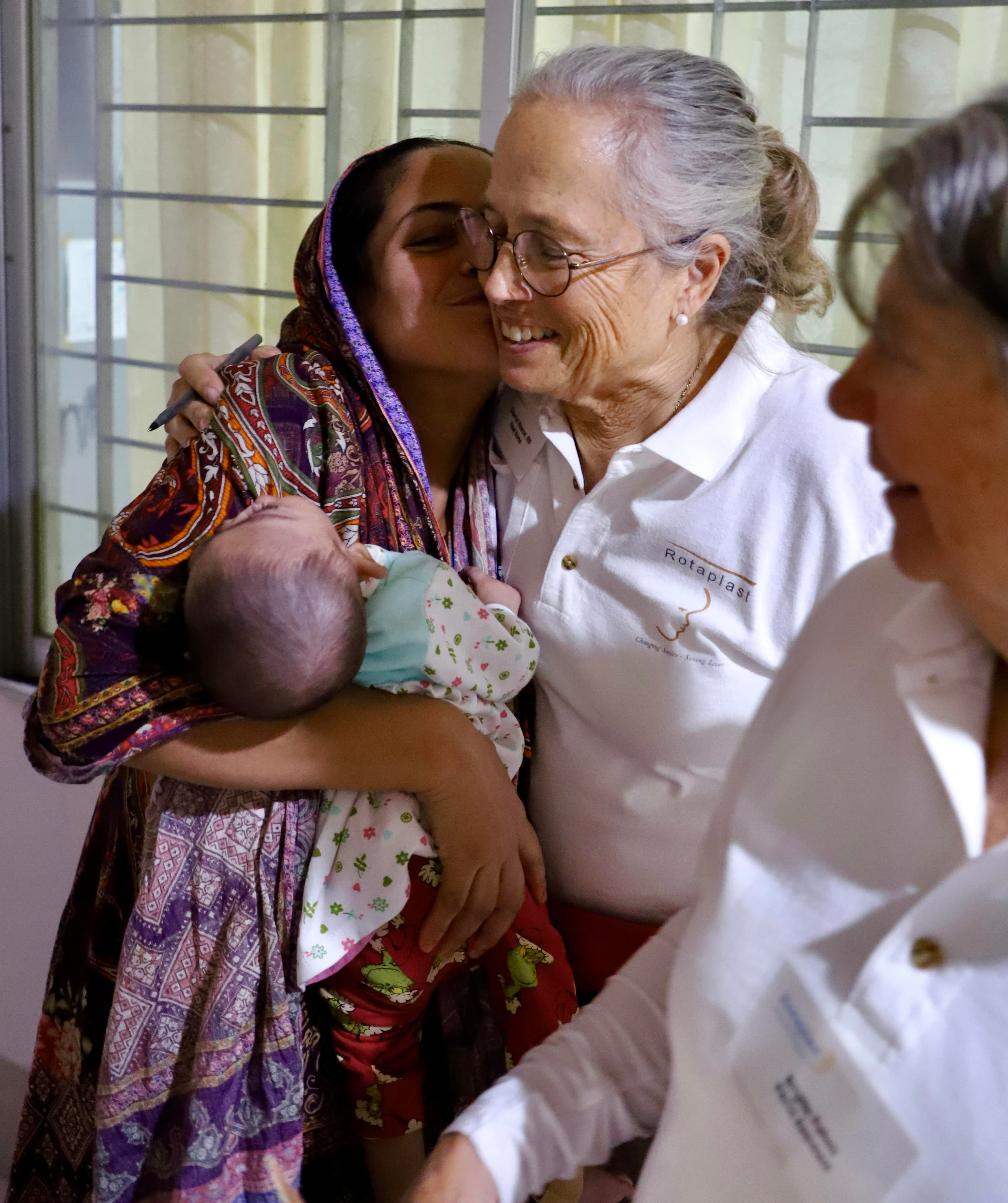 Rotaplast volunteer with a mother and child